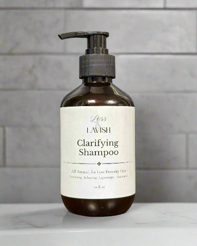 Amber pump bottle of Less & Lavish Clarifying Masculine Shampoo with white label, designed for deep‑cleansing hair and balancing scalp health.