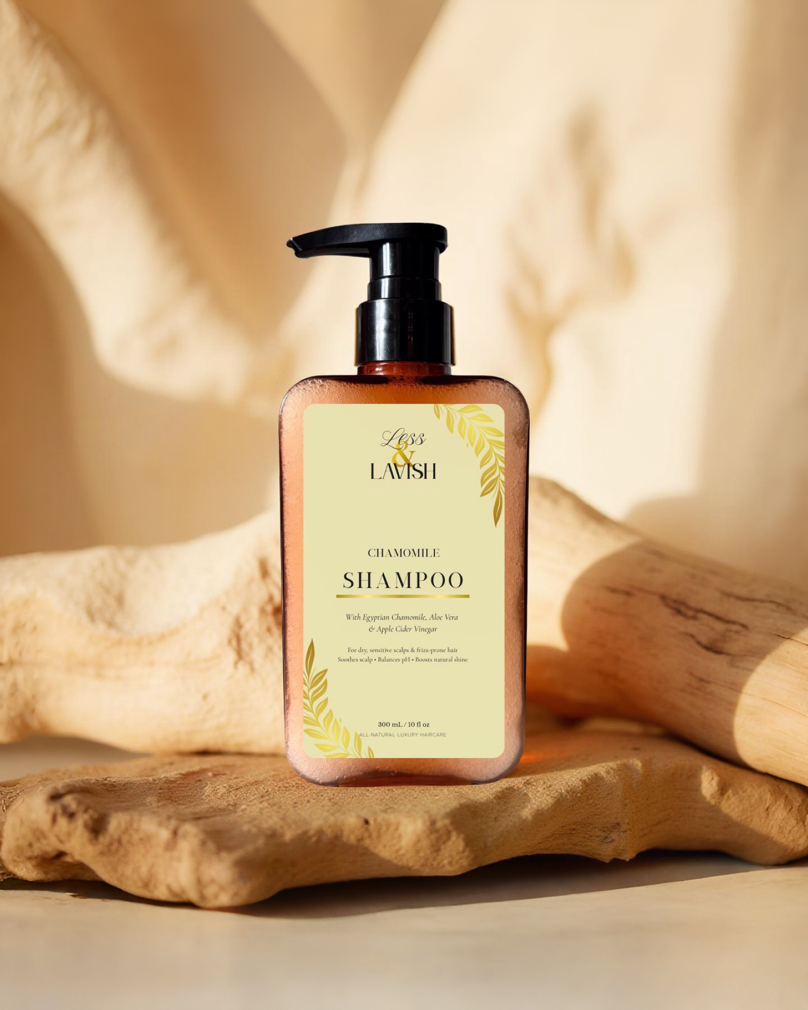 Less & Lavish chamomile shampoo bottle on a natural driftwood with a soft, warm background